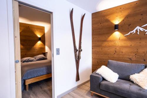 a bedroom with a bed and a mirror and a couch at Superbe vue, accès skis aux pieds, très agréable in Courchevel