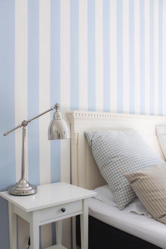 a bed with a lamp and a nightstand next to a bed with a pillow at Hotel Højbysø in Højby