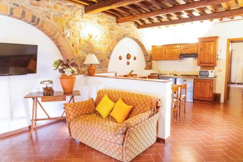 a living room with a couch and a kitchen at Borgo Il Poggio Agriturismo in Montaione