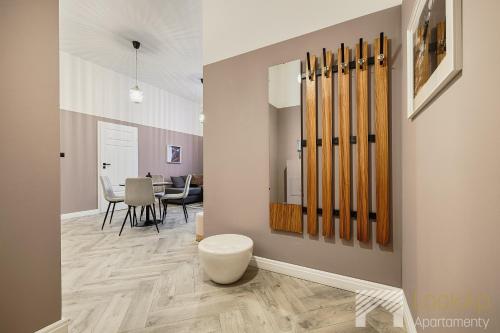 a hallway with a room with a table with chairs at Kolorova Apart by LookAp - darmowy parking w centrum Łodzi! in Łódź