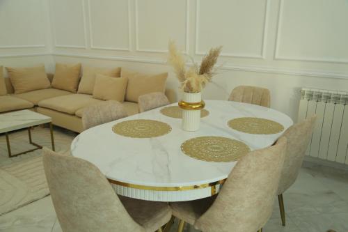 a white dining room table with chairs and a couch at Luxueux T3 à Oran. in Oran
