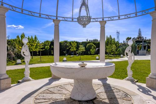 a large stone fountain in a park with a chandelier at Villam Vale da Estrela in Guimarães