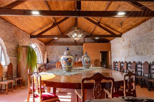 a dining room with a table with two vases on it at Villam Vale da Estrela in Guimarães