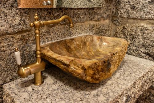 a sink in a bathroom with a gold faucet at Villam Vale da Estrela in Guimarães