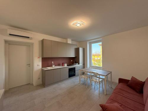 a kitchen and living room with a table and a couch at Residence - LA ROSA DEI VENTI in Ghedi