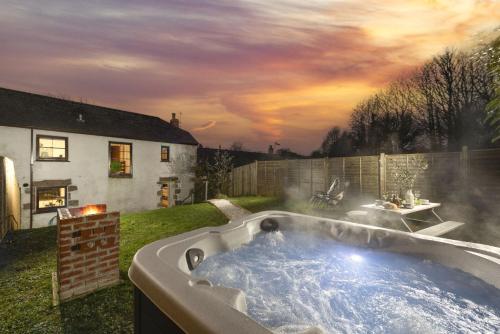 a hot tub in the yard of a house at The Old Hay Barn, Croft Hooper in Ludgvan