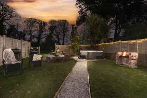 a backyard with a fire pit and a grill at The Old Hay Barn, Croft Hooper in Ludgvan
