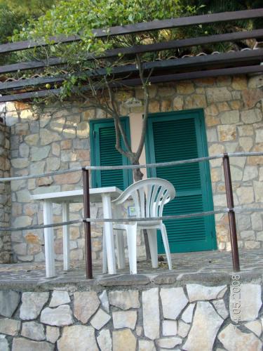 a white table and chair in front of a building at Hotel Club Torre Capovento in Sperlonga