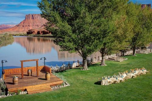 a dock with tables and chairs next to a lake at Red Cliffs Lodge Moab in Moab