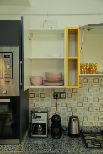 a kitchen with a counter with a stove and a microwave at Luxueux T3 à Oran. in Oran