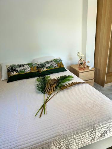 - une chambre dotée d'un lit blanc avec une plante dans l'établissement Villa dans un Camping - Le Joyau du Camping, à Puget-sur Argens