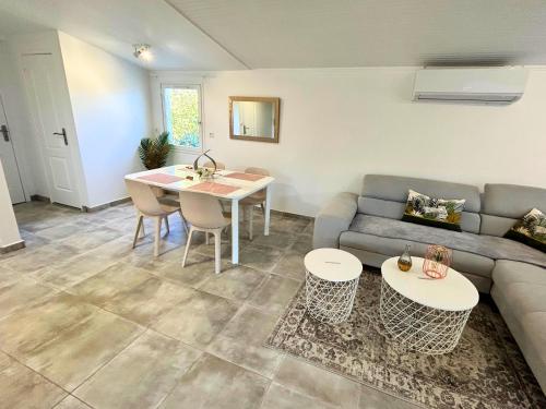 un salon avec un canapé et une table dans l'établissement Villa dans un Camping - Le Joyau du Camping, à Puget-sur Argens