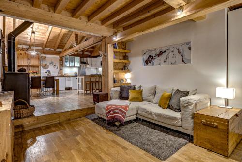 un salon avec un canapé et une cuisine dans l'établissement Tiki Lodge - hot tub & sauna, à Chamonix-Mont-Blanc