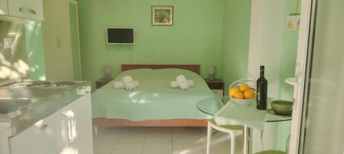 Un pequeño dormitorio con una cama con un tazón de naranjas en Apartments Mara, en Mali Lošinj