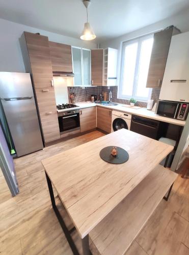 une cuisine avec une table en bois au milieu dans l'établissement DisneyLand - Paris 20min - Parking - 7 personnes, à Thorigny-sur-Marne