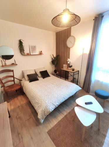 une chambre avec un lit, une table et une chaise dans l'établissement DisneyLand - Paris 20min - Parking - 7 personnes, à Thorigny-sur-Marne