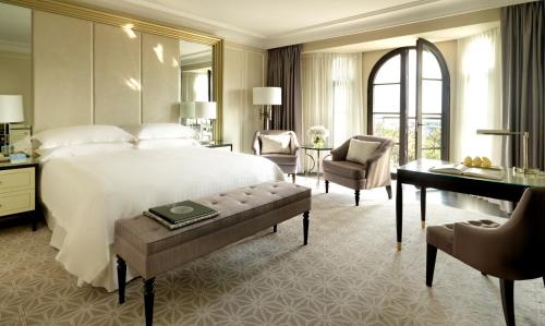 a bedroom with a large bed and a desk and chair at Four Seasons Hotel Baku in Baku