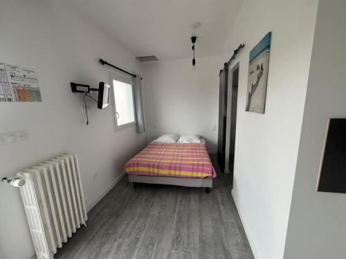 une petite chambre avec un lit et une fenêtre dans l'établissement Hotel Le Breton, à Indret
