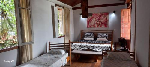 a room with two beds and a window at Casa com natureza in Rio de Janeiro
