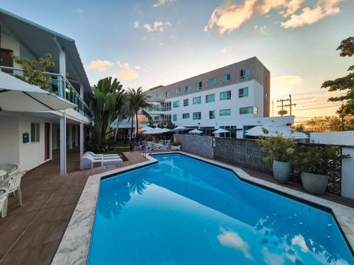 a swimming pool in front of a building at Hotel Vivenda dos Corais in Porto De Galinhas
