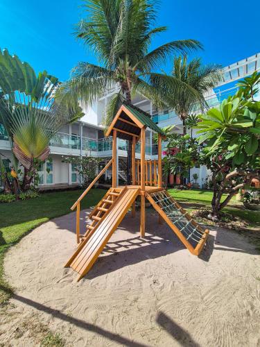 a wooden playground in front of a building at Hotel Vivenda dos Corais in Porto De Galinhas