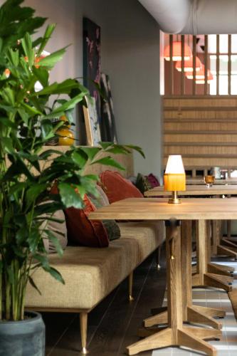 une table et un canapé avec une lampe dessus dans l'établissement Hotel Mai Amsterdam, à Amsterdam