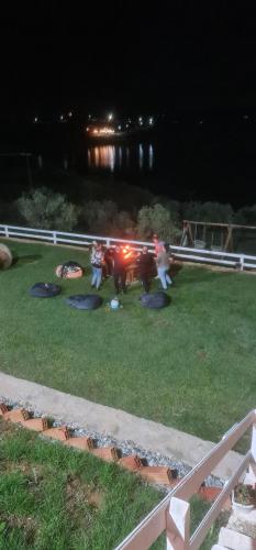 a group of people standing around a truck in the grass at Shtepiza Lio liqeni merhojes in Belsh