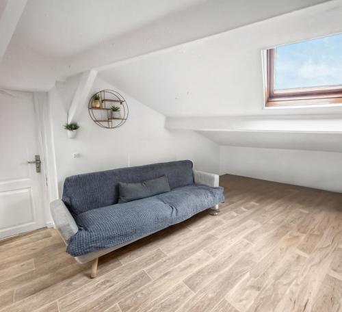 un salon avec un canapé bleu et une fenêtre dans l'établissement Charmant T2 lumineux,WiFi rapide, à La Courneuve