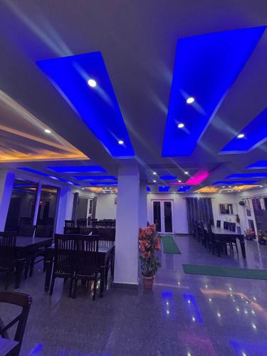 a room with blue lights and tables and chairs at Baakhli Guest House and Restaurant in Bhowāli