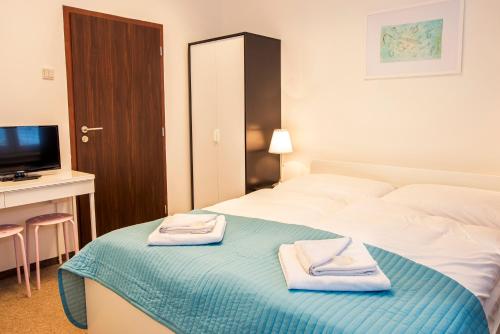 ein Hotelzimmer mit einem Bett mit Handtüchern darauf in der Unterkunft Petit Dependance in Bratislava