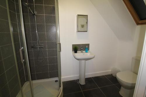 a bathroom with a shower and a sink and a toilet at Sutton House in Sutton in Ashfield