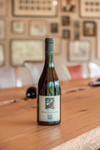 a bottle of wine sitting on a wooden table at Prackfolerhof in Fie allo Sciliar