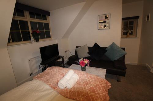 a bedroom with a bed and a couch and a table at Sutton House in Sutton in Ashfield