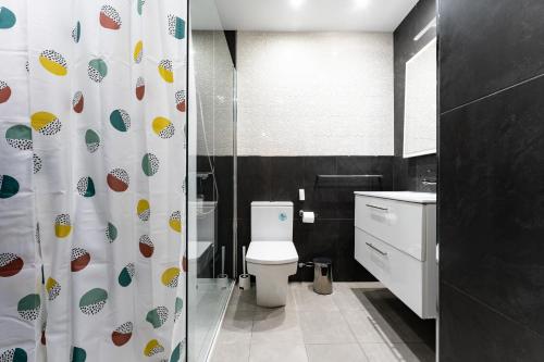 ein Badezimmer mit Toilette und Duschvorhang in der Unterkunft CT 350 - Faro's Marbella Beachapartment - perfect beachconection in Marbella