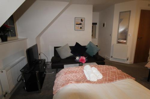 a bedroom with a bed and a couch at Sutton House in Sutton in Ashfield