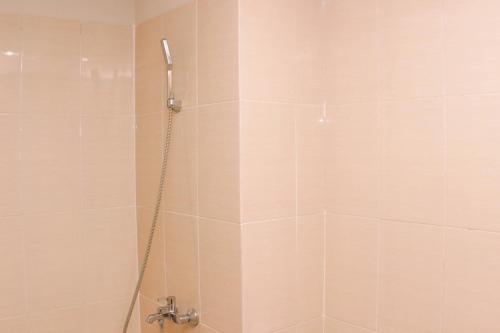 芝卡朗Cozy and Comfort Living 1BR at Oasis Cikarang Apartment By Travelio的带淋浴喷头的浴室