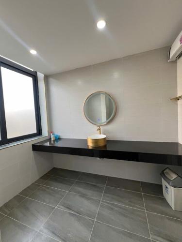 a bathroom with a mirror on a black counter at Liverpool House Mộc Châu in Mộc Châu