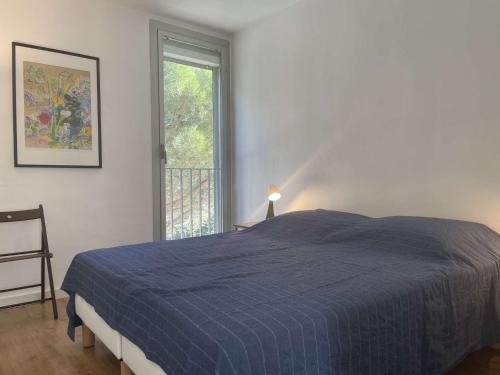 une chambre avec un lit bleu et une fenêtre dans l'établissement Appart 2 pièces 4 couchages BANYULS SUR MER BN100-D321, à Banyuls-sur-Mer