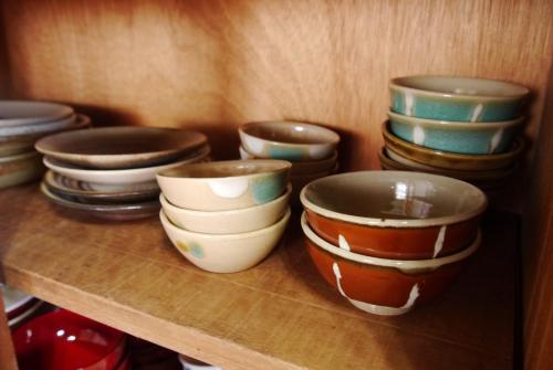 a group of bowls sitting on a shelf at サウナ&ステイ吉日荘-益子町のサウナ付の貸切古民家 BBQ 高速Wi-fi in Mashiko