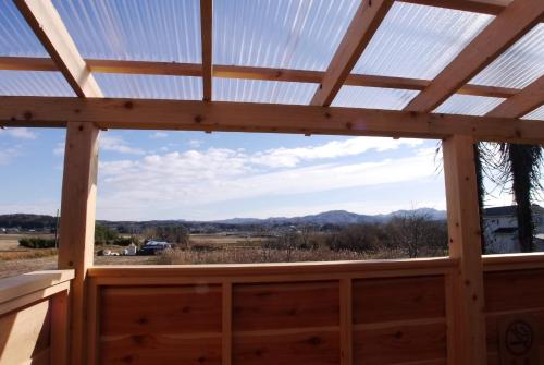 a view from the inside of a wooden cabin with a glass roof at サウナ&ステイ吉日荘-益子町のサウナ付の貸切古民家 BBQ 高速Wi-fi in Mashiko