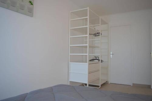 - une étagère blanche dans une chambre avec un lit dans l'établissement Appart 2 pièces 4 couchages BANYULS SUR MER BN160-61A, à Banyuls-sur-Mer