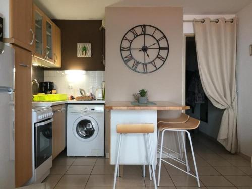 une cuisine avec un comptoir et une horloge au mur dans l'établissement Appart 2 pièces 2 couchages BANYULS SUR MER BN120-2106, à Banyuls-sur-Mer