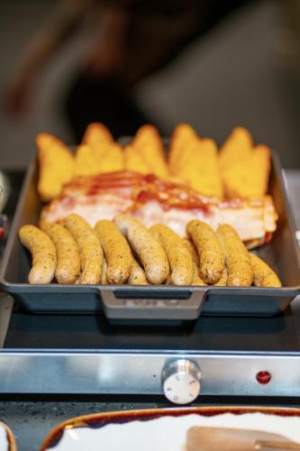 a tray of hot dogs and snacks on a grill at OREA Place Seno in Prague