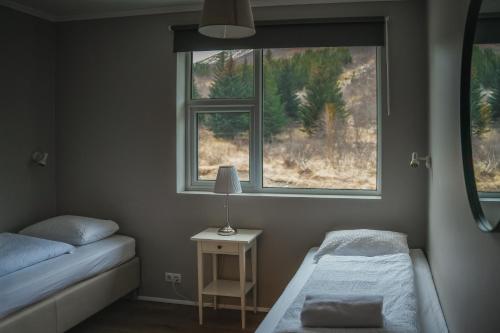a bedroom with two beds and two windows at Hótel Laugarvatn in Laugarvatn