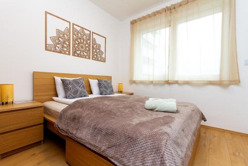 a bedroom with a large bed and two windows at River Apartment Harmony by NW in Budapest