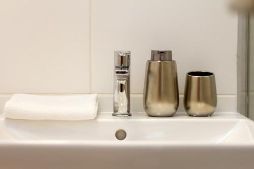 a bathroom sink with two bottles and a towel at River Apartment Harmony by NW in Budapest