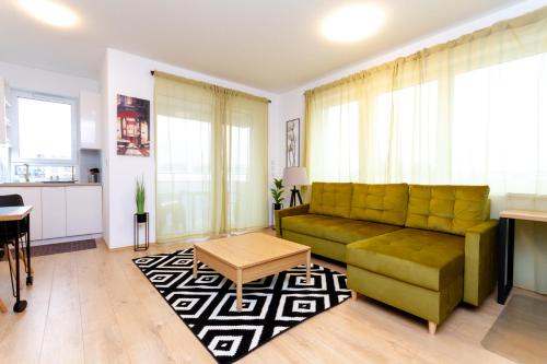 a living room with a green couch and a table at River Apartment Harmony by NW in Budapest
