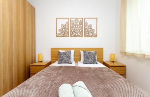 a bedroom with a large bed with two night stands at River Apartment Harmony by NW in Budapest