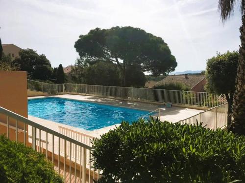 une piscine entourée d'une clôture dans l'établissement HYEGUY Appartement pour 3 personnes en rez de jardin avec piscine commune à Giens, à Hyères