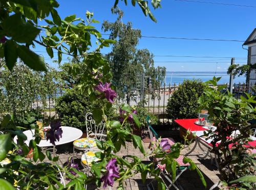 a garden with a table and chairs and flowers at Hotel Mozart in Rorschach